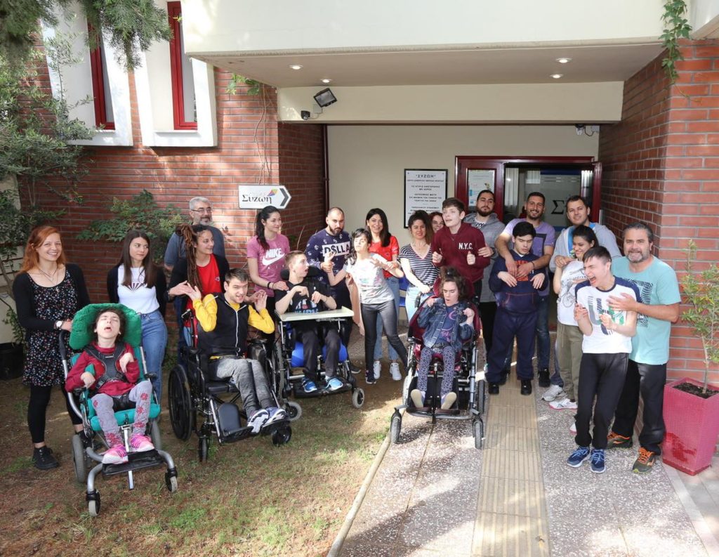 Φωτογραφία με όλα τα παιδιά και το προσωπικό του συλλόγου στην είσοδο του κέντρου διημέρευσης - ημερήσιας φροντίδας Συζωή